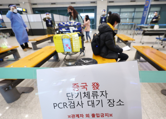 8일 오후 인천국제공항 제1여객티미널을 통해 입국한 중국발 입국자들이 방역 관계자의 안내를 받고 있다. 연합뉴스
