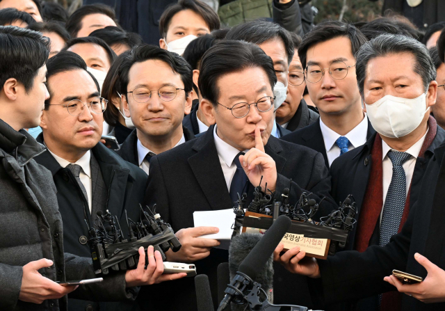 10일 경기도 수원지방검찰청 성남지청에 출석한 이재명(가운데) 더불어민주당 대표가 포토라인에 선 뒤 입장문을 낭독하기 전 한 시민에게 조용히 해달라는 손짓을 하고 있다. 성남=권욱 기자