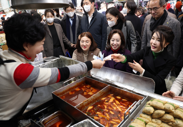 김건희(오른쪽) 여사가 11일 대구 서문시장을 방문해 만두 등을 맛본 뒤 음식 값을 치르고 있다. 연합뉴스