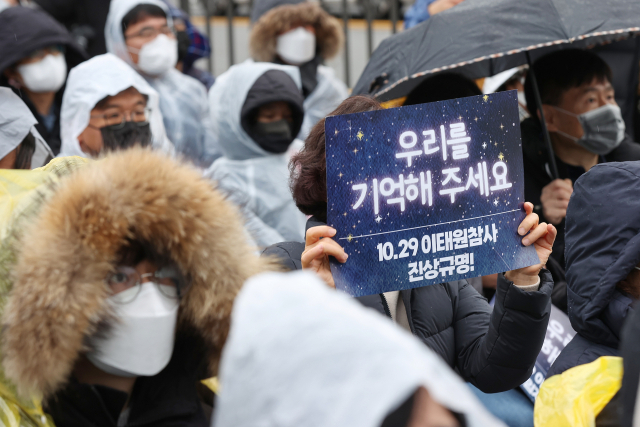 14일 오후 서울 용산구 전쟁기념관 앞에서 열린 10.29 이태원 참사 유가족협의회·10.29 이태원 참사 시민대책회의 주최 3차 시민추모제에서 한 참석자가 손팻말을 들고 있다. 연합뉴스