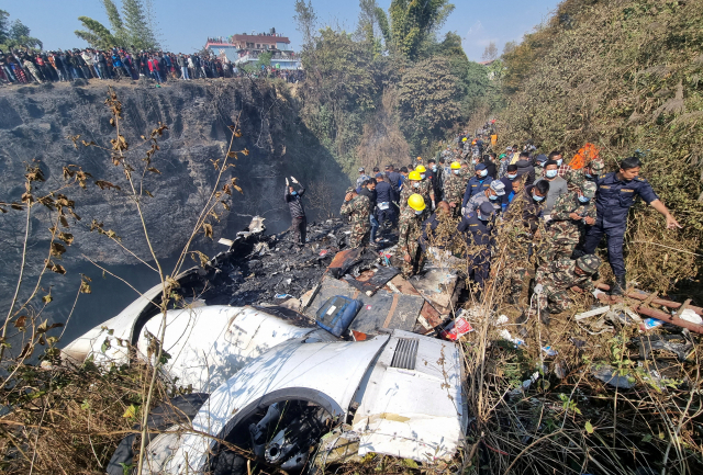 네팔 구조요원들이 15일 서부 도시 포카라 세티협곡에 추락한 항공기(네팔 예티항공 소속 ATR72기) 사고 현장에서 시신을 수습하고 있다. 로이터연합뉴스