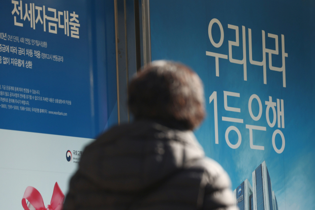 서울 시내 우리은행 지점 앞을 한 시민이 걸어가고 있다./연합뉴스
