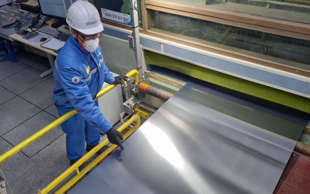 한 포스코 직원이 19일 복구를 완료한 포항제철소 스테인리스 1냉연 공장에서 제품을 살펴보고 있다. 사진 제공=포스코