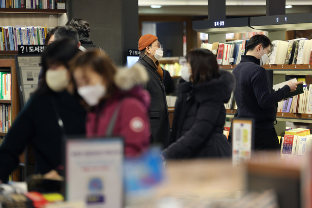 정부가 오는 30일부터 실내 마스크 착용을 '의무'에서 '권고'로 완화한 가운데 20일 오후 서울 시내의 한 대형서점에서 시민들이 마스크를 착용하고 있다. 연합뉴스