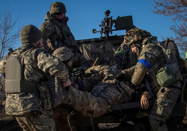 우크라이나 군인들이 지난 23일(현지시간) 도네츠크 지역에서 전투중 부상당한 동료 장병을 후송하고 있다. 로이터·연합뉴스