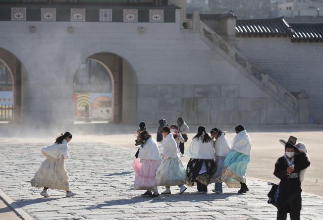 한파특보가 발령된 24일 오후 경복궁을 찾은 관광객들이 바람을 맞으며 걷고 있다./연합뉴스