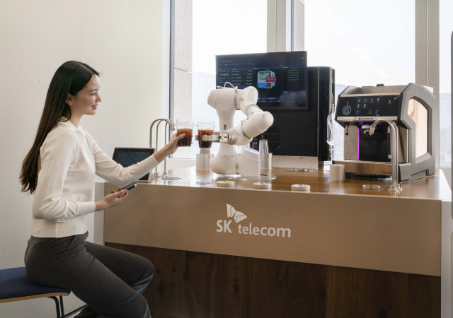 SK텔레콤과 두산로보틱스가 만든 ‘AI바리스타 로봇’이 직접 커피를 만들어 보이고 있다. /사진제공=SK텔레콤