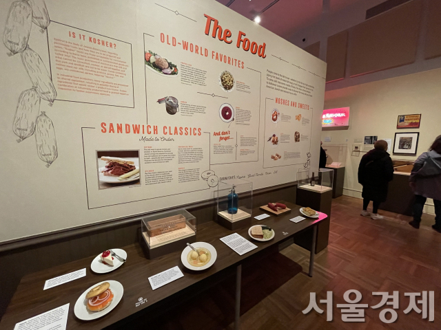 전시장에는 유대계 이민자들이 ‘델리카트슨(Delicatessen)’에서 즐겨먹던 베이글, 파스트라미 샌드위치 등에 대한 설명과 음식 모형이 전시돼 있다.