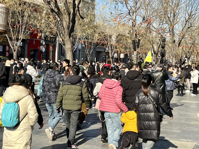 중국 베이징 중심의 상업지구 ‘첸먼다지에’에서 4일 노란 깃발을 든 가이드를 단체 관광객들이 뒤따르고 있다. 김광수특파원