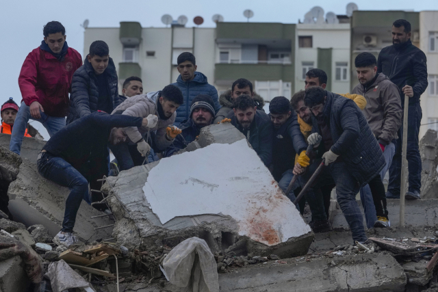 6일(현지시간) 튀르키예 남부 아다나에서 실종자 수색에 나선 시민들이 강진으로 붕괴한 건물 잔해를 들어올리고 있다. 이날 튀르키예에서는 규모 7.8, 7.5의 강진이 잇따라 발생하고 80여 차례 여진이 일어나 건물 5천600여 채가 붕괴했다. 시리아와 국경을 맞댄 지역에서 일어난 이번 지진으로 튀르키예와 시리아에서 현재까지 약 3천500명이 사망했다. /연합뉴스