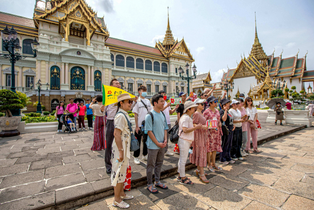 중국 단체 관광객들이 7일 태국 방콕의 왕궁 앞에서 기념 촬영을 위해 포즈를 취하고 있다. 신화연합.