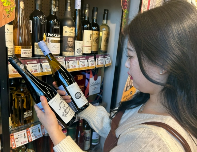 이마트24 관계자가 점포에서 와인 상품을 살펴보고 있다./사진 제공=이마트24
