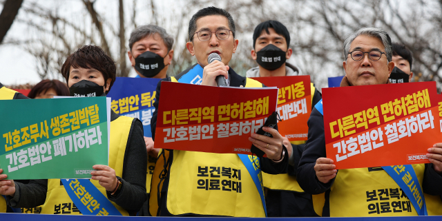 13일 오전 서울 여의도 국회 앞에서 보건복지의료연대 소속 13개 단체가 주최한 간호법 강행처리 규탄 선포식에서 이필수 대한의사협회장(가운데)이 투쟁선포문을 낭독하고 있다. 연합뉴스