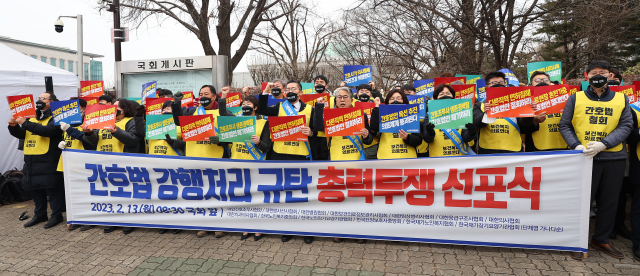 대한의사협회·대한간호조무사협회·대한임상병리사협회·한국요양보호사중앙회를 비롯한 보건복지의료연대 소속 단체 관계자들이 13일 오전 서울 여의도 국회 앞에서 간호법 강행처리 규탄 선포식을 열고 구호를 외치고 있다. 연합뉴스스