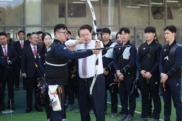 윤석열 대통령이 14일 충북 진천선수촌에서 열린 2023 대한민국 체육비전 보고회를 마친 뒤 양궁장에서 활시위를 당기고 있다. 연합뉴스