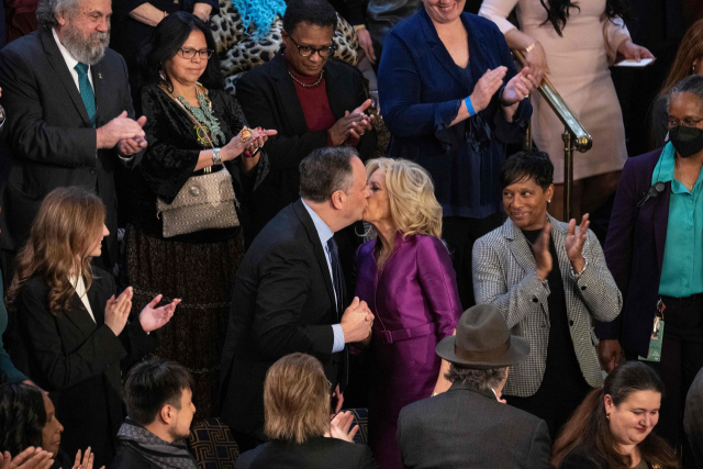 보라색 원피스를 입은 질 바이든 박사가 카멀라 해리스 부통령의 남편 더글러스 엠호프와 입맞춤을 나누고 있다. AFP연합뉴스