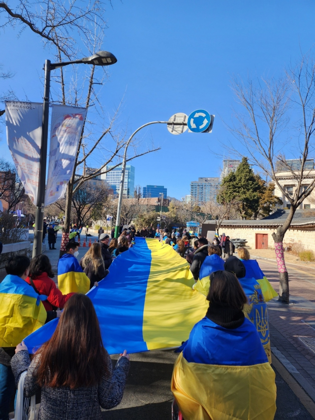 19일 대형 우크라이나 깃발을 든 집회 참가자들이 덕수궁 돌담길 주변에서 가두행진에 나서고 있다. 이정훈 견습기자