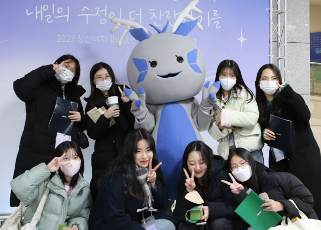 지난 20일 서울 강북구 성신여자대학교 운정그린캠퍼스에 마련된 OT 포토존에서 신입생들이 학교 공식 캐릭터 '수룡이'와 사진 촬영을 하고 있다./ 성신여대 제공