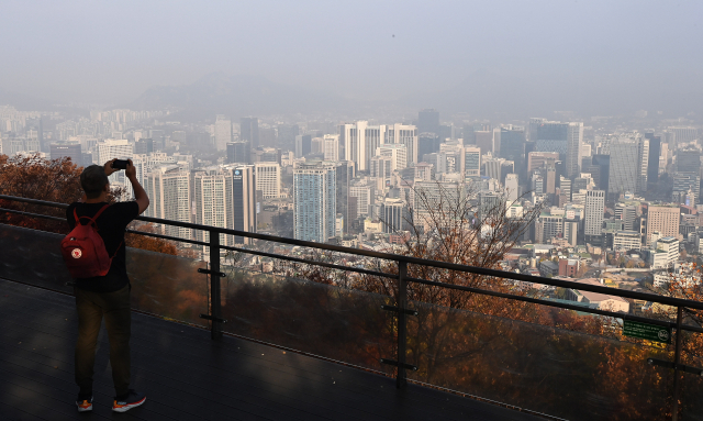 초미세먼지 농도가 '나쁨' 수준을 보인 지난해 11월 서울 중구 남산에 오른 한 외국인이 안개와 미세먼지로 뒤덮인 도심을 바라보고 있다. 오승현 기자