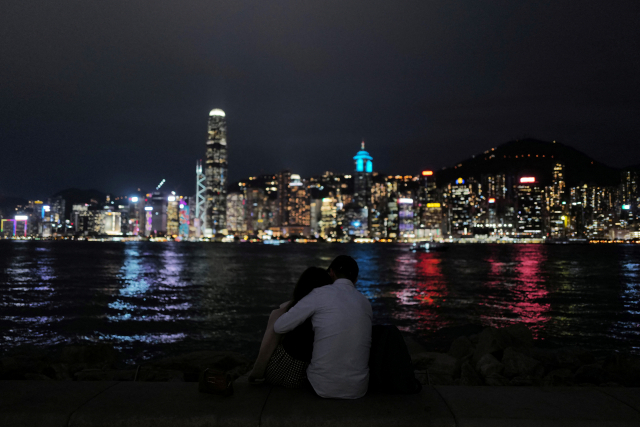 홍콩 빅토리아 항구 옆에 14일 발렌타인 데이에 한 커플이 앉아 있다. 로이터연합.