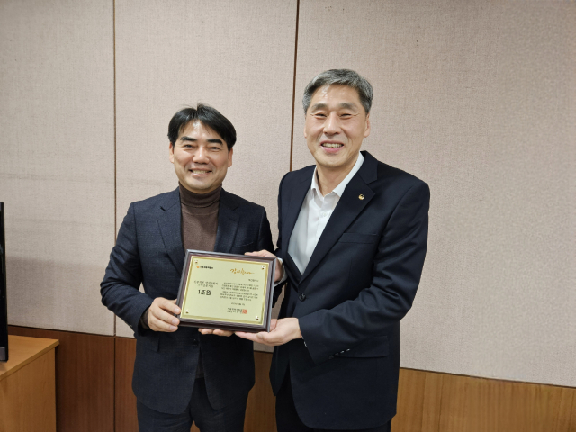 신중호(오른쪽) 신용회복위원회 부산·경남 지역단장이 이성권 부산시 경제부시장에게 소액금융지원 누적금액 1조원 달성 기념패를 전달하고 기념촬영을 하고 있다./사진제공=신용회복위원회