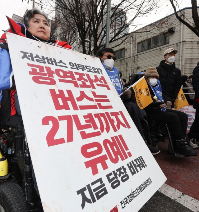 지난 19일 전국장애인차별철폐연대(전장연) 회원이 서울 서초구 남부터미널 앞에서 장애인 이동권 촉구 집회를 열고 있다. 연합뉴스