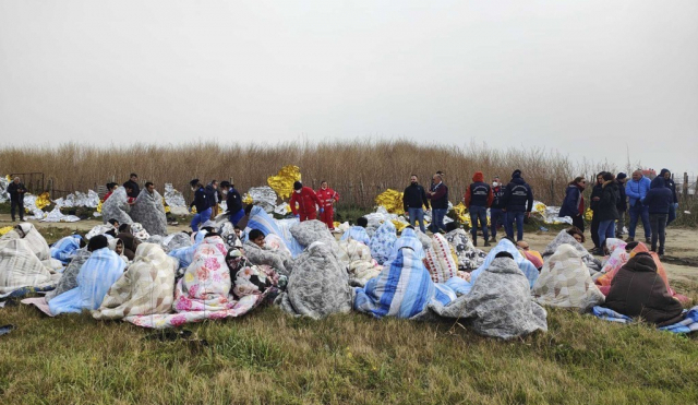 이탈리아 서남부 크로토네시 앞바다에서 난파된 난민선에 타고 있던 생존자들이 해변에서 담요를 덮어쓴 채 구호를 기다리고 있다. AP=연합뉴스