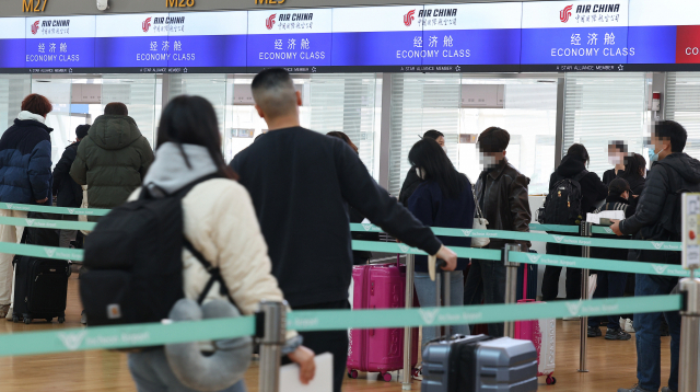 지난 20일 오후 인천국제공항 제1여객터미널 한 중국 외항사 탑승수속 카운터에서 탑승객들이 탑승 수속을 밟고 있다. 연합뉴스