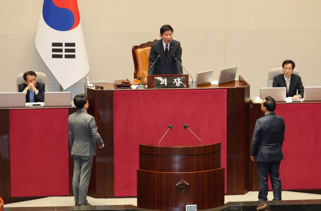 김진표 국회의장이 27일 국회에서 열린 본회의에서 여야 원내 지도부를 불러 양곡관리법 일부 개정 법률안을 3월 첫 본회의에서 처리할 것을 발표하자 박홍근 더불어민주당 원내대표와 진성준 원내수석부대표가 단상 앞으로 나와 항의하고 있다. 연합뉴스