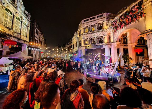 관광객들이 중국 하이난성 하이커우 치러우 거리에서 라이브 밴드의 공연을 관람하고 있다. 신화연합.