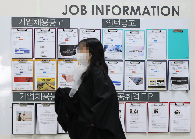서울 성북구 성신여대에서 한 졸업생이 취업 안내 게시물 앞을 지나고 있다. 연합뉴스