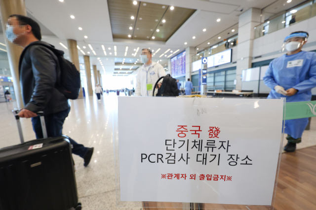 중국발 입국자의 도착 후 코로나19 PCR 검사 의무 해제를 이틀 앞둔 27일 오후 인천국제공항 제1여객터미널 입국장에서 중국에서 온 탑승객들이 방역관계자의 안내를 받아 검사센터로 이동하고 있다. 연합뉴스