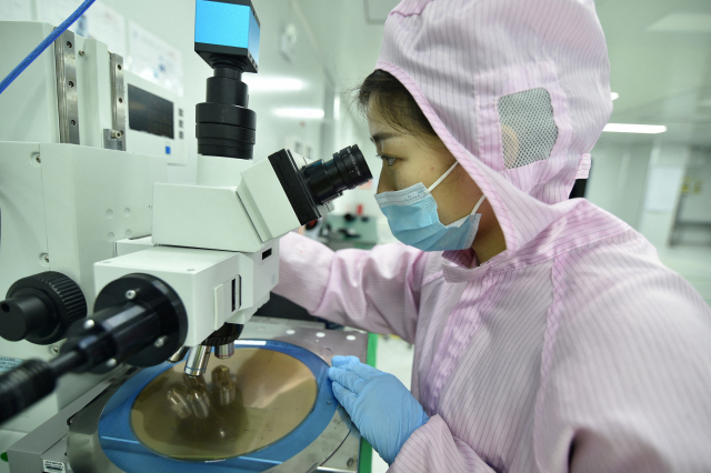 한 반도체 공장에서 직원이 현미경으로 웨이퍼를 확인하고 있다. 로이터연합뉴스