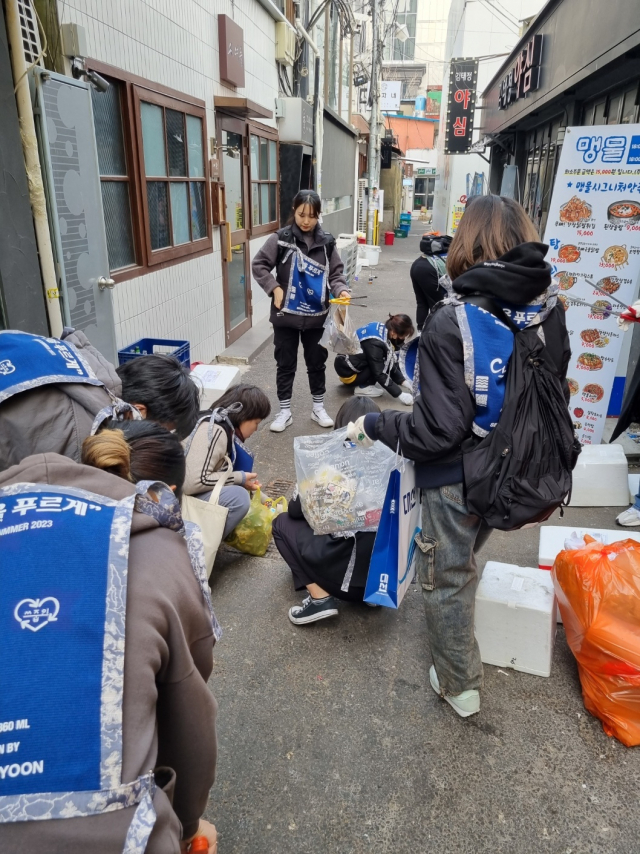 대선주조 임직원들과 쓰줍인 회원들이 부산 서면 상권을 청소하고 있다./사진제공=대선주조