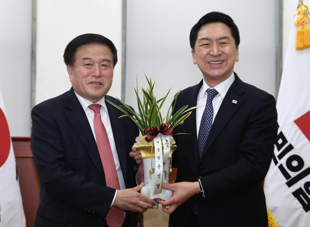 김기현 국민의힘 대표가 9일 서울 여의도 국회 국민의힘 당 대표실에서 이진복 대통령실 정무수석비서관을 만나 대통령이 보낸 축하 난을 받고 있다. 성형주 기자