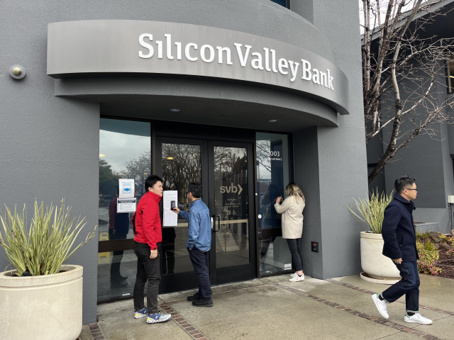 10일(현지 시간) 오전 미국 캘리포니아주 샌타클래라에 있는 실리콘밸리은행(SVB)이 폐쇄된 가운데 예금 인출을 위해 방문한 고객들이 굳게 닫힌 문 안을 들여다보고 있다.