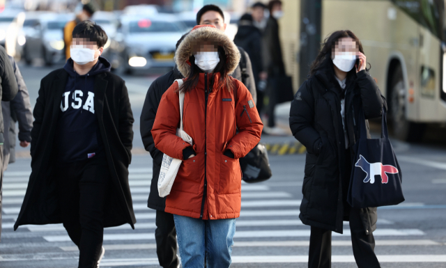 아침 기온이 큰 폭으로 떨어져 추운 날씨를 보이는 지난 13일 오전 서울 종로구 광화문에서 두꺼운 외투를 입은 시민들이 몸을 움츠리며 걸어가고 있다. 연합뉴스