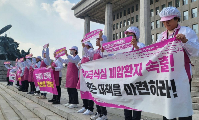 전국학교비정규직노동조합 급식실 조합원들이 지난해 11월 8일 서울 영등포구 국회 본관 계단에서 학교급식실 폐암 산재 대책 마련과 노동 환경 개선 예산 편성을 요구하고 있다. 연합뉴스