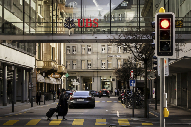 18일(현지 시간) 크레디트스위스(CS)와 UBS의 건물이 있는 스위스 취리히의 한 거리를 시민들이 걷고 있다. 스위스 정부는 UBS를 상대로 CS를 인수할 것을 요청하고 주말 새 협상을 진행하고 있다. AP연합뉴스