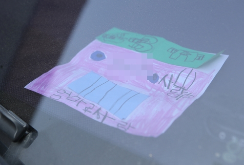 지난 18일 인천시 미추홀구 한 주택에서 숨진 채 발견된 일가족 소유 차량에 아이가 쓴 것으로 보이는 그림편지가 놓여 있다. 이 편지에는 삐뚤빼뚤한 글씨로 “사랑해. 엄마 사랑”이라는 문구가 적혀 있다. 연합뉴스