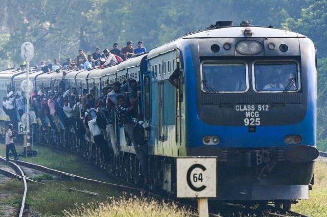 스리랑카 콜롬보 시민들이 공공부문 파업 여파로 철도 운행이 줄어들자 열차에까지 매달리면서 이동하고 있다. 스리랑카는 IMF 구제금융 협상조건으로 소득세율의 대폭 인상을 단행하기로 했다. AFP연합뉴스