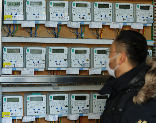 정부가 내년 1분기 전기요금 인상을 발표한 지난해 12월30일 서울 시내의 한 오피스텔 건물에서 관계자가 전자식전력량계를 살펴보고 있다. 연합뉴스