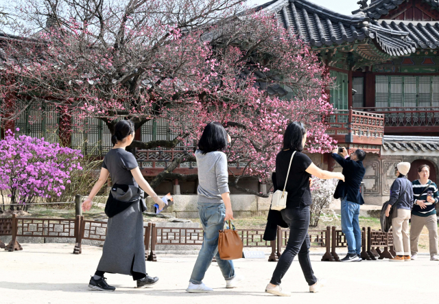 서울 낮 기온이 24도까지 오르며 따뜻한 날씨를 보인 22일 서울 종로구 창덕궁을 찾은 시민들이 겉옷을 벗고 산책하고 있다. 권욱 기자