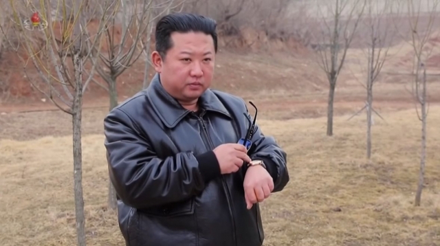 북한 조선중앙TV가 2022년 3월 25일 공개한 영상에서 김정은 북한 국무위원장이 시계를 가리키고 있다. 사진=조선중앙TV
