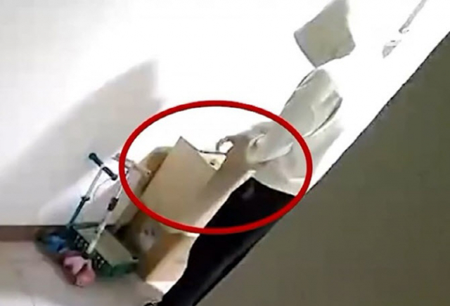 피해 여성 B씨의 집 앞에서 ‘몰래 카메라’를 수거하는 선배 A씨. SBS 보도화면 캡처