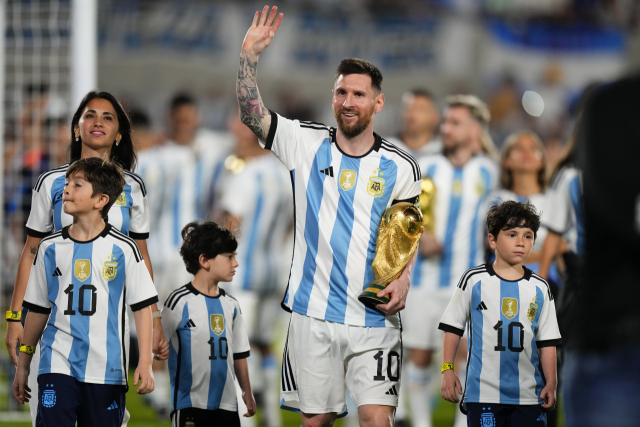 아르헨티나 대표팀의 리오넬 메시가 24일 파나마와의 평가전 뒤 월드컵 트로피를 들고 아내, 그리고 세 아들과 함께 그라운드를 돌며 홈 팬들에게 인사하고 있다. AP연합뉴스