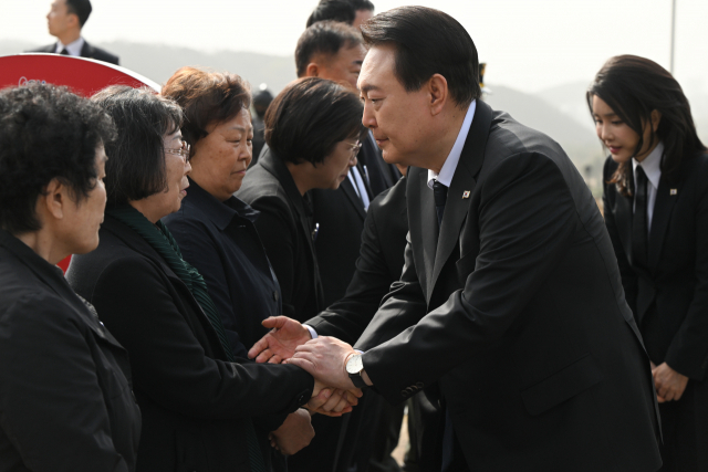 윤석열 대통령과 김건희 여사가 24일 대전 유성구 국립대전현충원에서 열린 제8회 서해수호의 날 기념식에 앞서 제2연평해전 및 연평도 포격전 전사자 묘역을 참배하며 유족과 인사하고 있다./연합뉴스