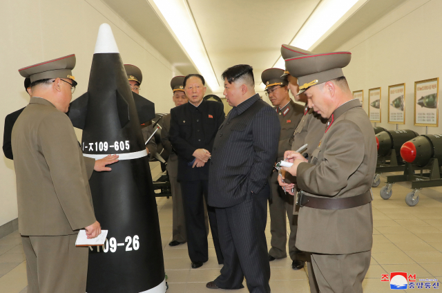 김정은 국무위원장이 초대형 방사포 탄두부로 추정되는 발사체 앞에서 지도하고 있다.
