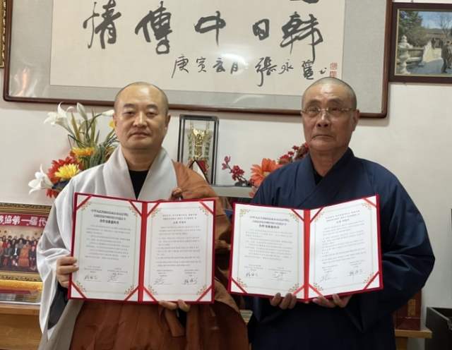 제주 법화사 도성(왼쪽) 스님과 중국 법화원 스옌쉐 스님이 27일 불교 전통문화 교류 의향서를 체결한 뒤 기념 촬영을 하고 있다. 사진 제공=제주도