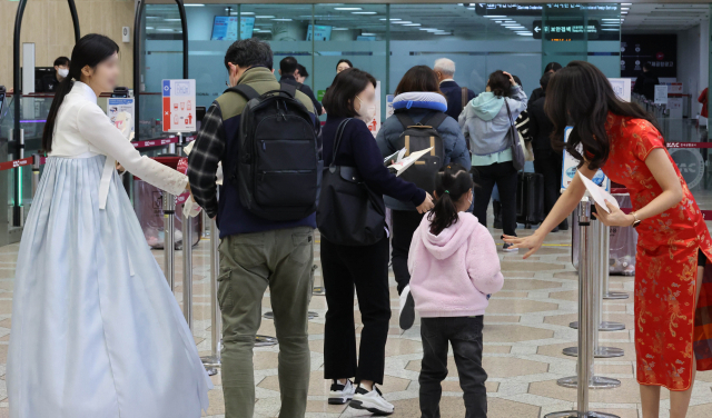 27일 한국공항공사 관계자들이 김포공항에서 김포~베이징·상하이 노선 운항 재개를 기념해 출국하는 승객들에게 기념품을 나눠주고 있다. 권욱 기자